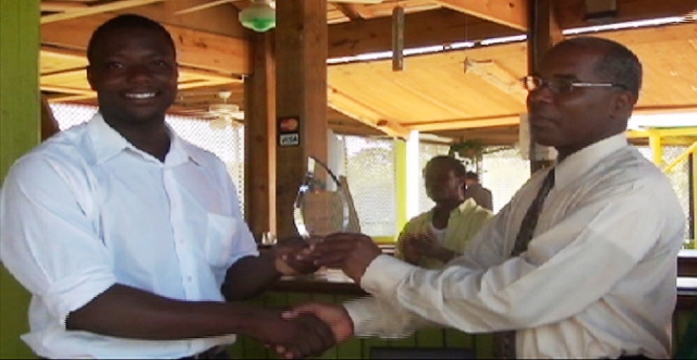 Permanent Secretary in the Ministry of Social Development and Culture Mr. Alsted Pemberton presents recognition award to entrepreneur Mr. Randy Jeffers (white shirt) for contribution to tourism and hospitality.